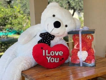 מארז מתנה לאישה הכולל דובי לבן בגודל מטר וחצי, כרית לב עם כיתוב i love you, ודובי פרחים אדום בגודל 40 סמ.